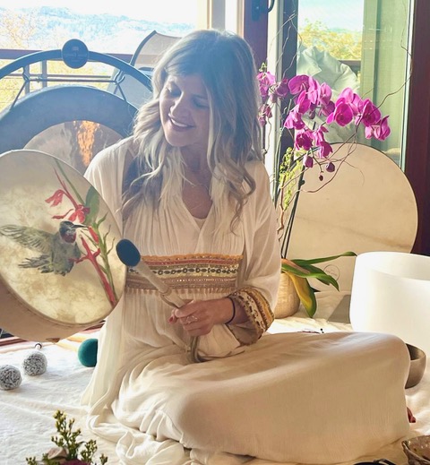 Lisa with hand drum and orchids by the window