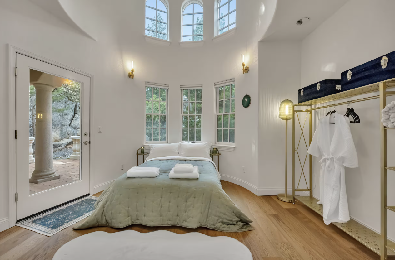 Light-filled bedroom with arched windows and robes